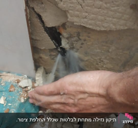 יד עוצרת דליפת מים מקיר סדוק